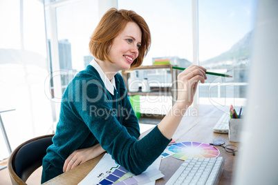 smiling hipster interior designer looking at her computer