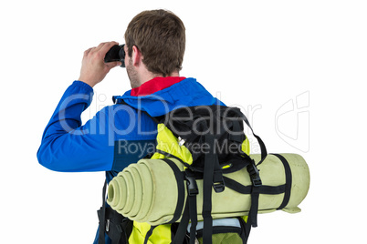 Side view of backpacker looking through binoculars