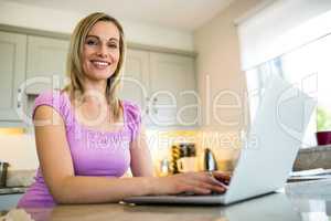 Pretty blonde woman having coffee and using laptop