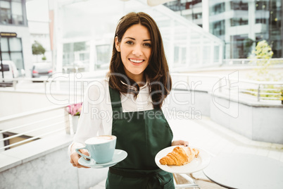 Waitress posing with coffee and croissant