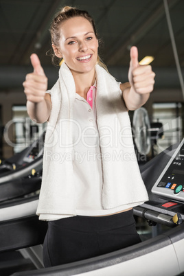 Smiling woman in sportswear showing thumbs up