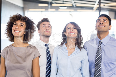 Portrait of business team looking up in office