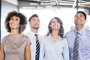 Portrait of business team looking up in office