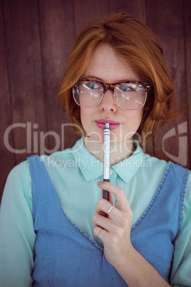 Cute red haired hipster chewing a pen