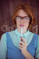 Cute red haired hipster chewing a pen