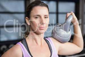 Smiling woman holding heavy kettlebell