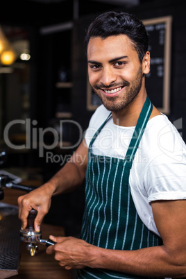 Smiling barista preparing coffee with machine