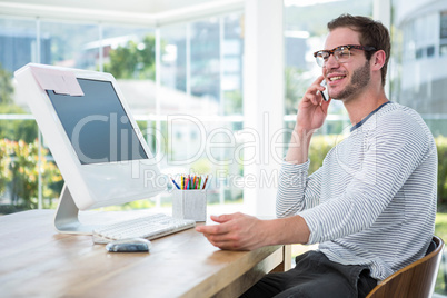 Handsome man working on computer and on the phone