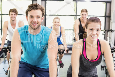 Fit group of people using exercise bike together