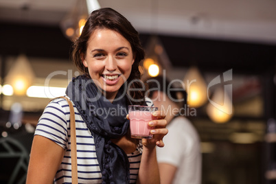 Smiling brunette drinking a beverage