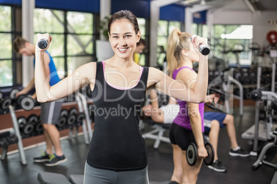 Smiling woman working out with dumbbells