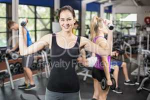 Smiling woman working out with dumbbells