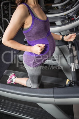Pregnant woman running on treadmill
