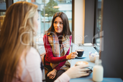 Pretty friends chatting over coffee