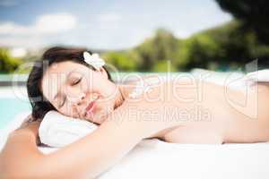 Woman lying on massage table with salt scrub on back