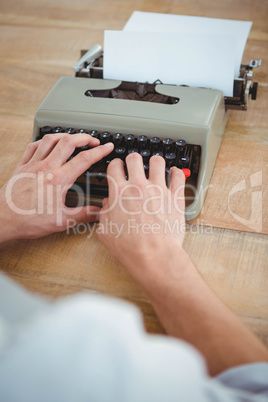 masculine hands typing on old typewriter