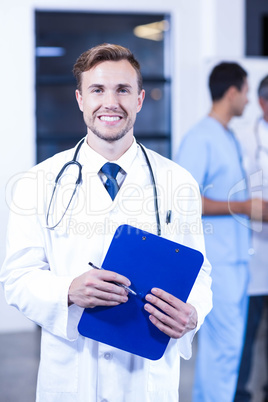Doctor holding medical report and smiling at camera