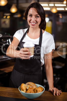 Pretty barista holding disposable cup