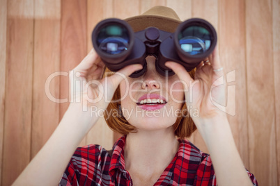 smiling hipster woman looking through binoculars