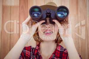 smiling hipster woman looking through binoculars