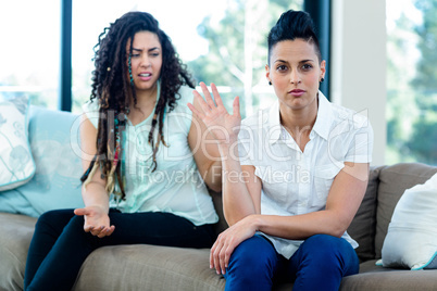 Unhappy lesbian couple sitting on sofa Unhappy lesbian couple sitting on sofa