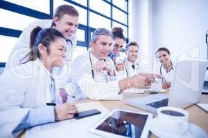 Medical team looking into laptop and having a discussion
