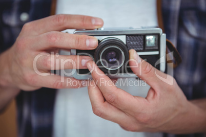 View of masculine hands holding a retro camera