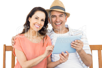 Couple on bench using tablet