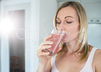 Pretty blonde woman holding her homemade smoothie