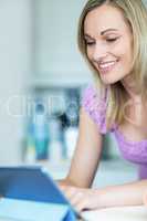 Pretty blonde woman using tablet computer