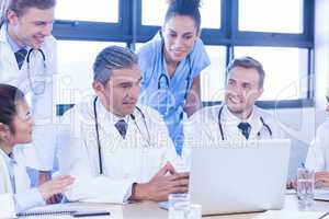 Medical team looking into laptop and having a discussion