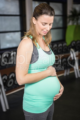 Pregnant blonde touching her belly