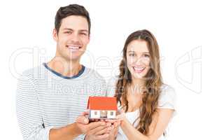 Happy couple holding miniature house