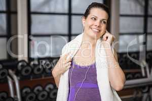 Smiling pregnant woman listening music and touching her belly