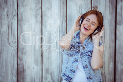 smiling hipster woman listening to loud music through headphones