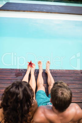 Young couple sitting by poolside