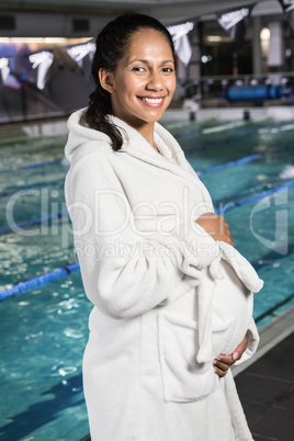 Pregnant woman with bathrobe touching her belly Pregnant woman with bathrobe touching her belly