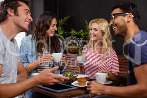 Smiling friends enjoying coffee together