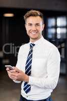 Portrait of businessman typing a text message in office