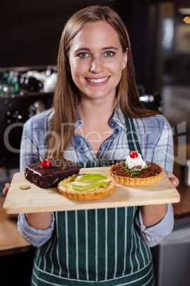 Pretty barista holding desserts