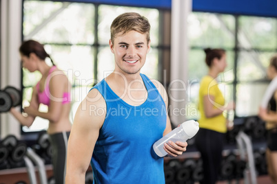 Muscular man posing with athletic women behind