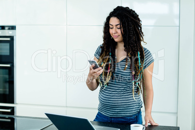 Woman standing near worktop with a mobile phone