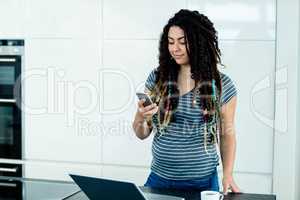 Woman standing near worktop with a mobile phone