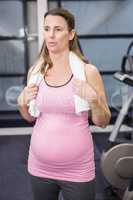 Tired pregnant woman standing in the gym