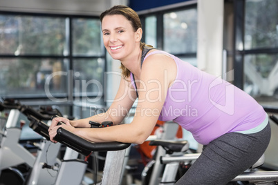 Smiling woman using exercise bike