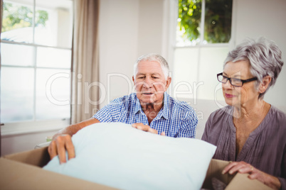 Senior couple unpacking a cardboard box