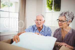 Senior couple unpacking a cardboard box