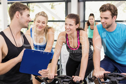 Fit group of people using exercise bike together