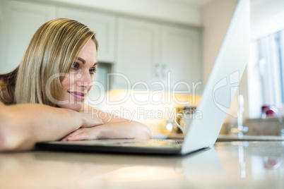 Pretty blonde woman looking at laptop