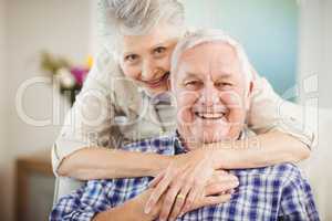 Senior woman embracing man at home